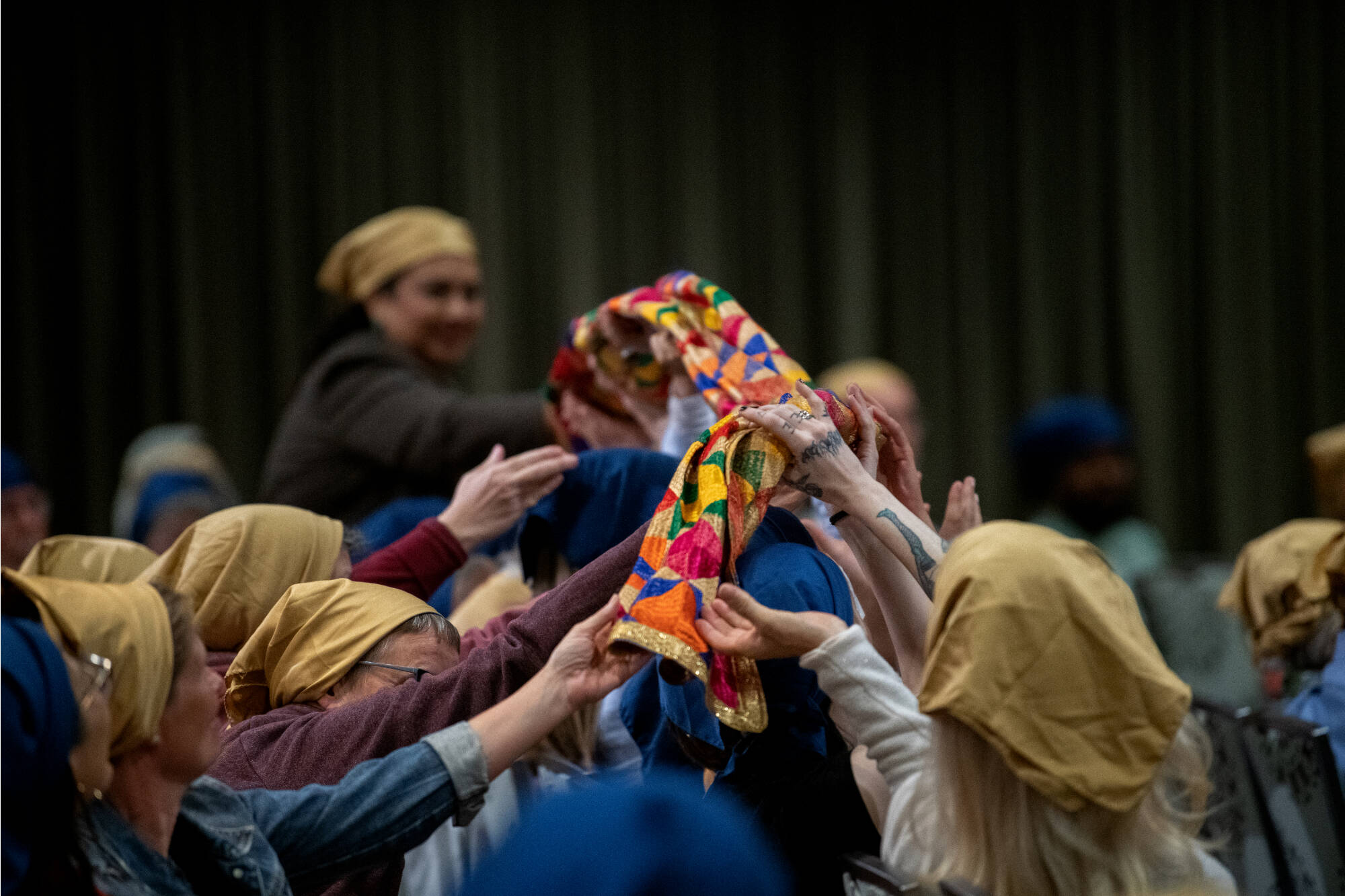 A group of people passing a colorful scarf to each other